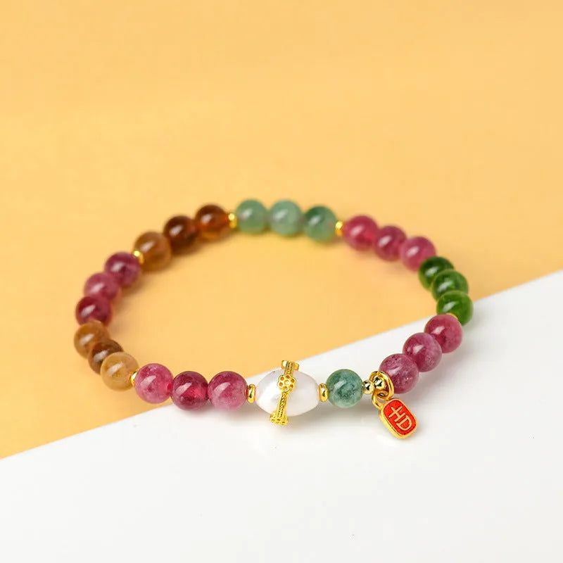 Close-up of a chalcedony bracelet with geometric 6.5mm beads in a tourmaline colour on a wrist.