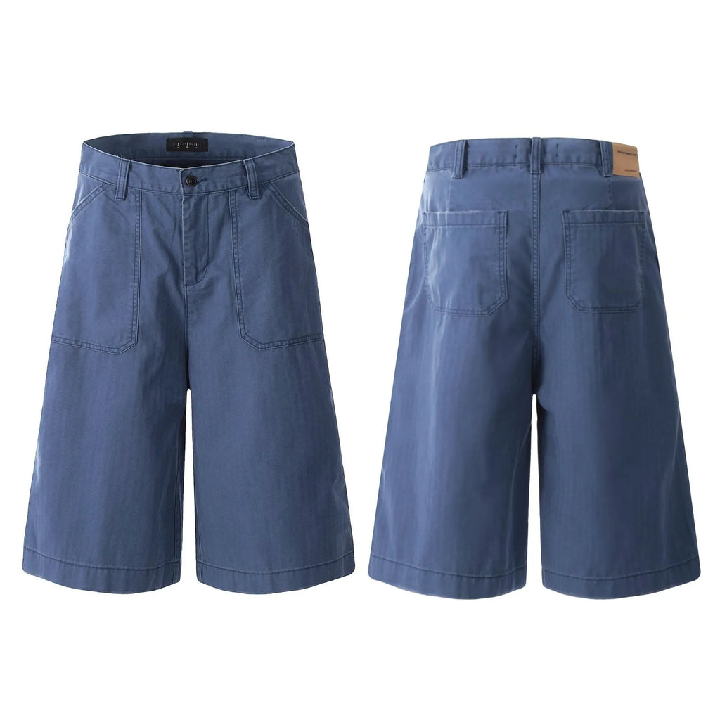 Men's French blue cotton shorts, loose straight-leg fit, mid-rise waist with zipper fly, lying flat.