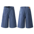 Men's French blue cotton shorts, loose straight-leg fit, mid-rise waist with zipper fly, lying flat.