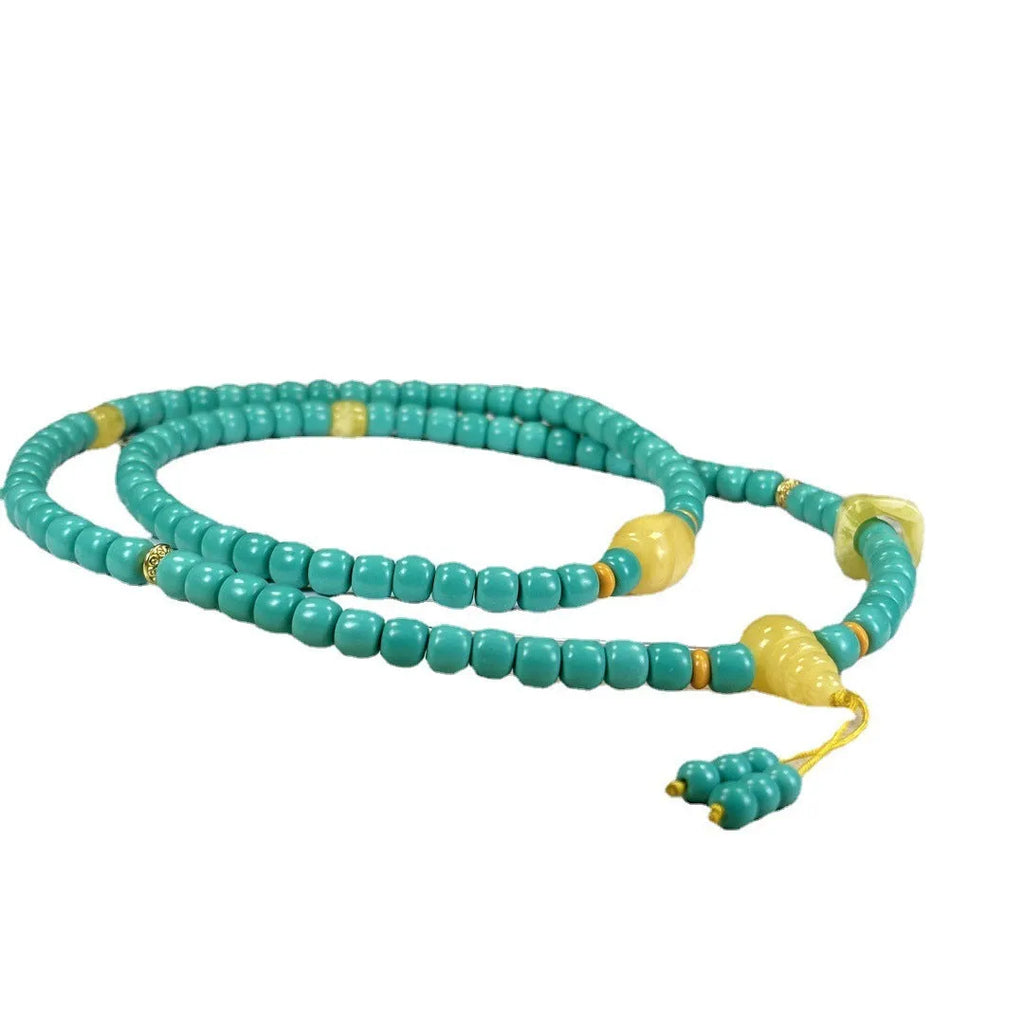Close-up of a hand-woven mesh flower turquoise pendant on an adjustable ball bead necklace.