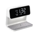 White 3-in-1 bedside lamp with wireless charging pad, LCD alarm clock display, and touch controls.