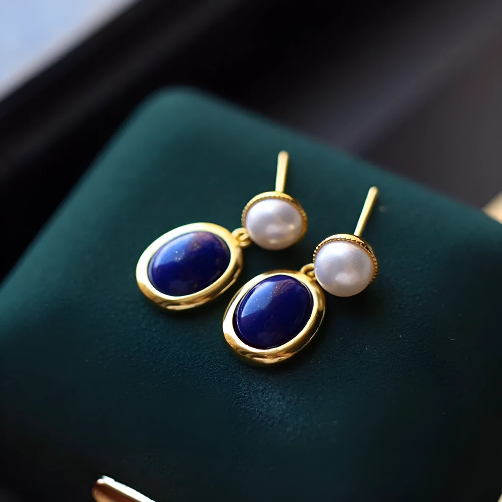 A pair of sterling silver drop earrings with a blue lapis lazuli pearl and auspicious patterns.