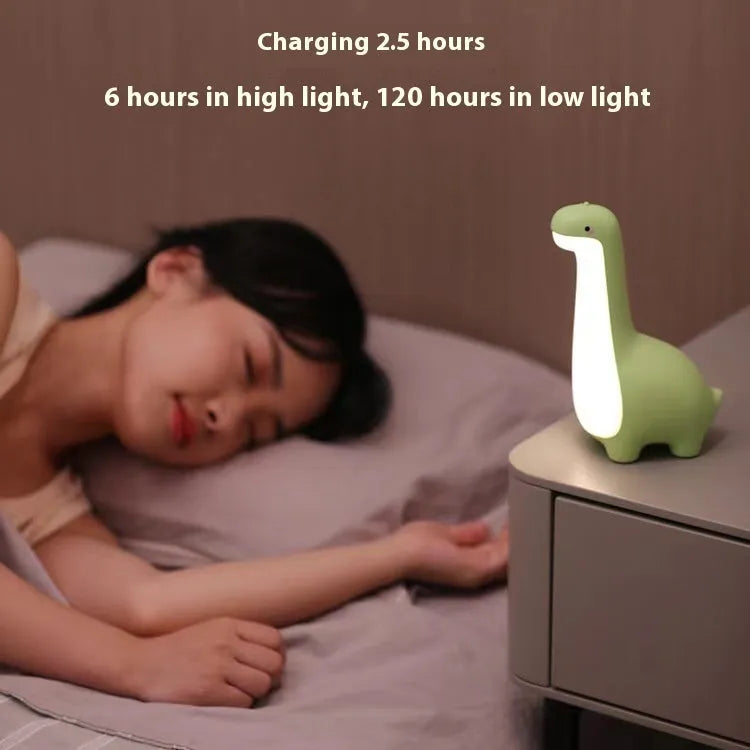 Dinosaur night light in lemon yellow with warm 3000K glow on a bedside table, USB charging cable included