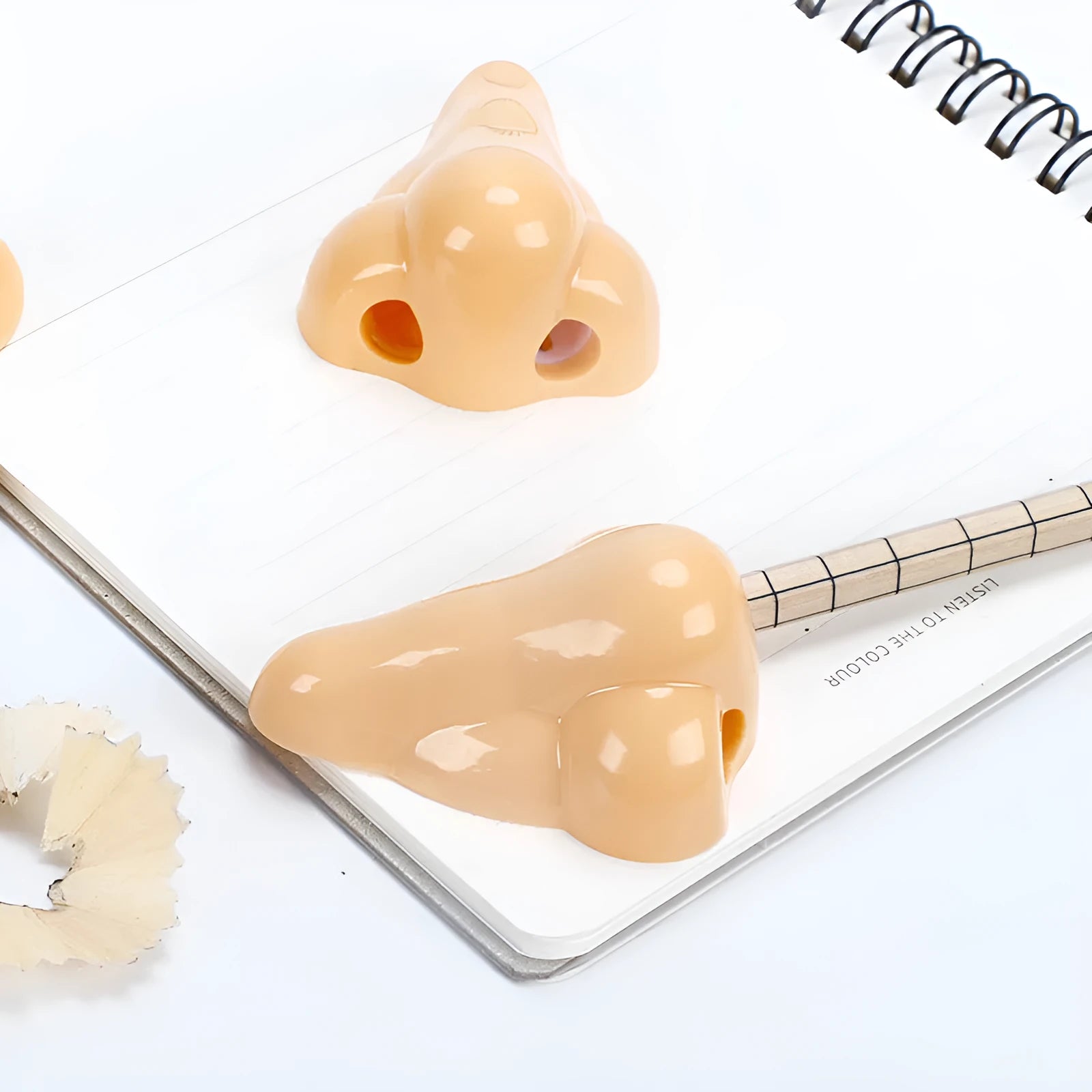 Flesh colour plastic big nostril manual pencil sharpener with geometric shape.