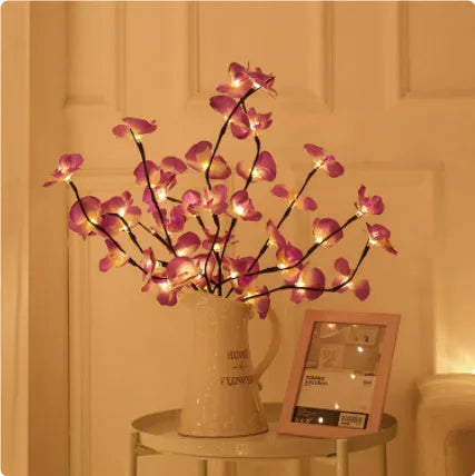 Pink silk orchid LED branch light, 65cm long, with glowing warm white LEDs on fabric petals and plastic stem.