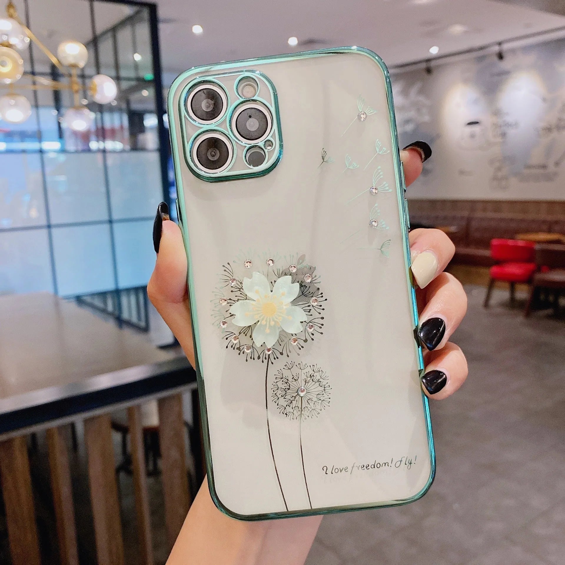 Green iPhone case with 3D white floral design and a silver rotating kickstand extended from the back.