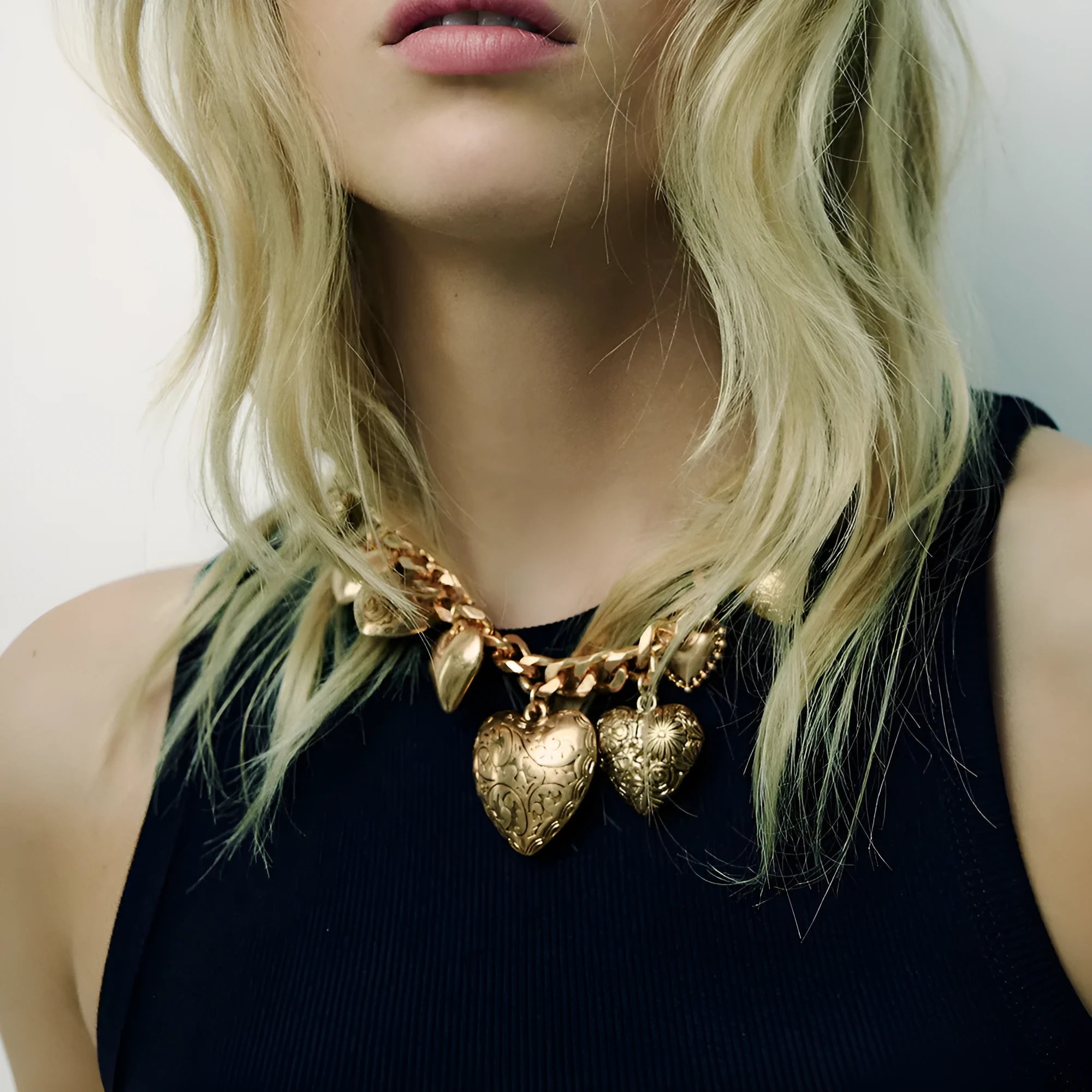 Gold-coloured carved heart pendant necklace on an adjustable metal chain.
