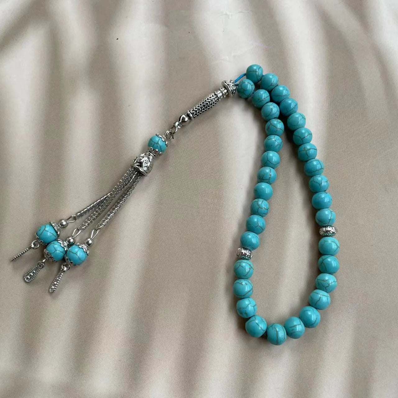 Handmade Muslim prayer bracelet made of sky blue 8mm stone beads on a wrist.