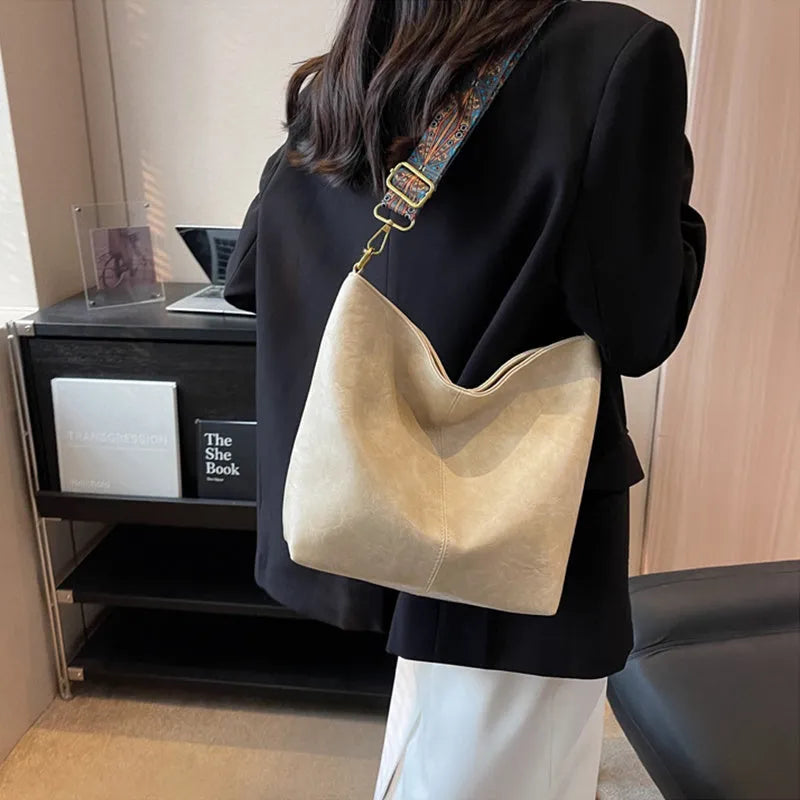 Retro bucket bag with wide shoulder strap, solid colour in beige, shown from front angle