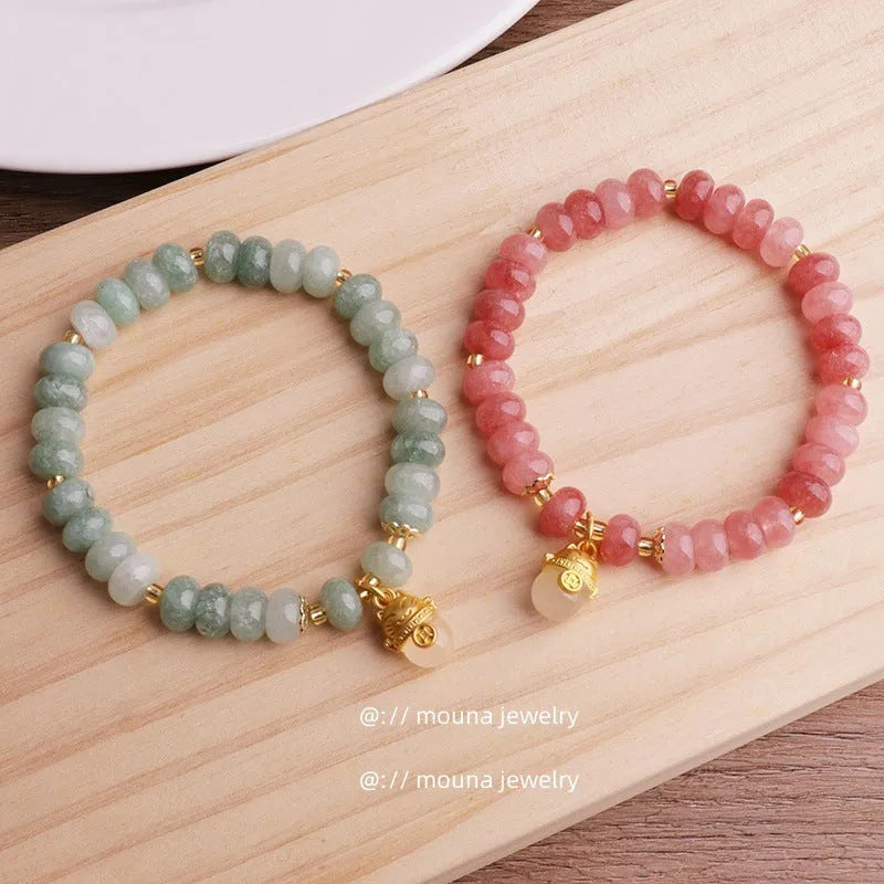 Women's retro strawberry quartz bracelet with lucky cat charm on wrist
