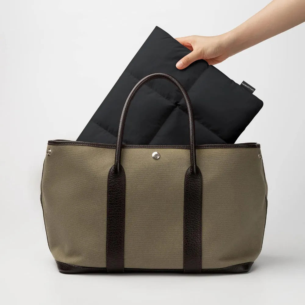 Soft fluffy laptop sleeve in black showing sewing thread details and open to reveal polyester lining