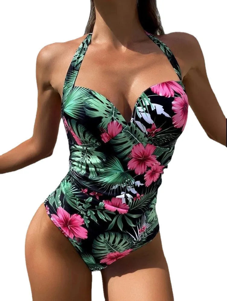 Women's printed halter neck one-piece swimsuit on a hanger, showing backless design.