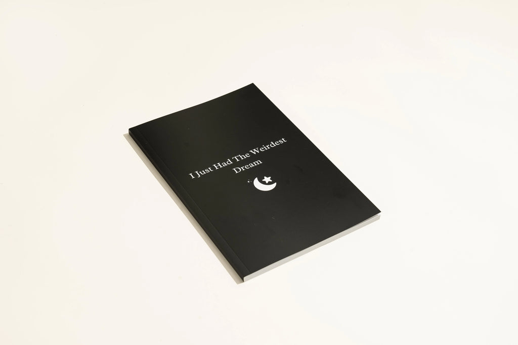 Black hardback A5 dream journal notebook with debossed title on soft-touch cover.