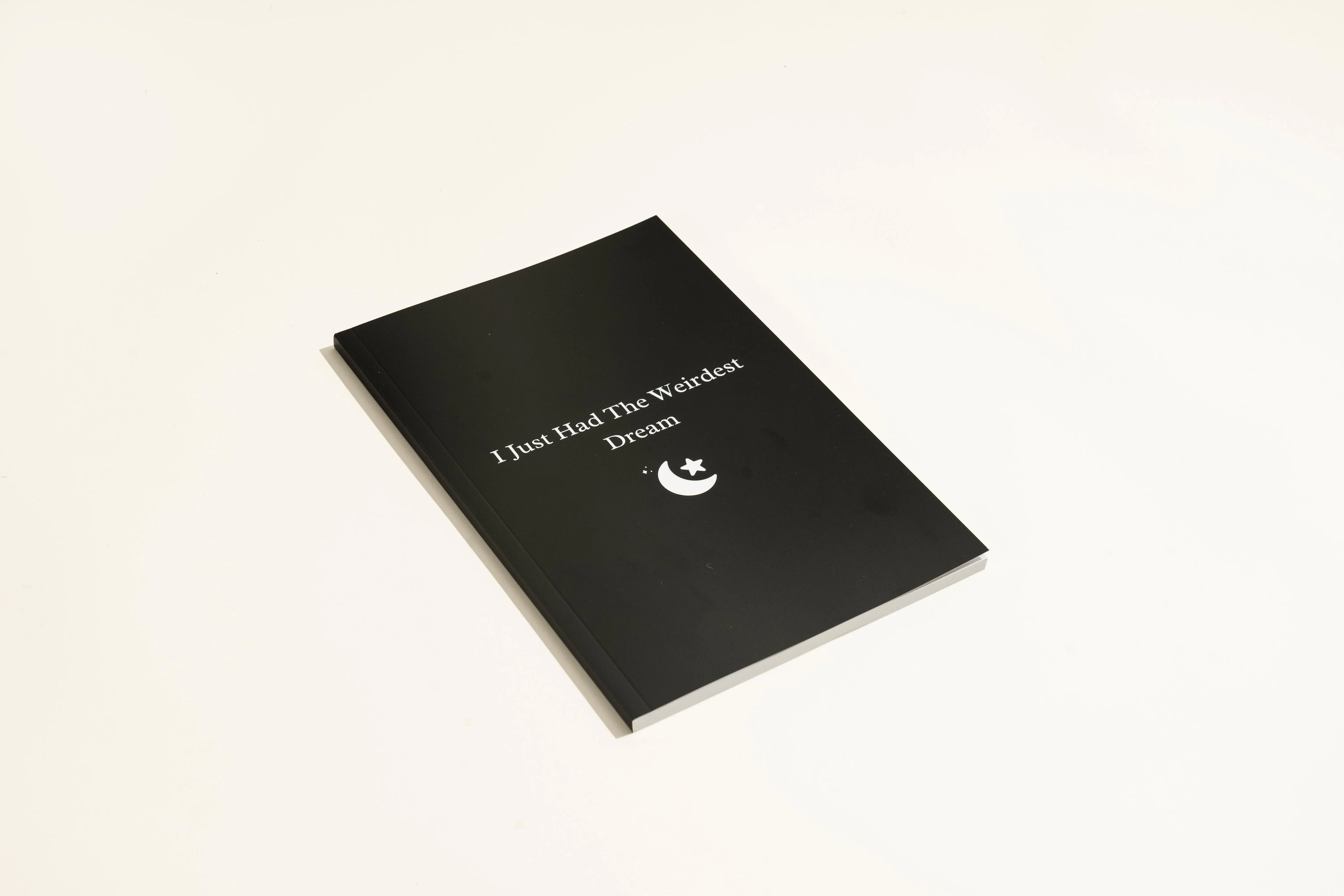 Black hardback A5 dream journal notebook with debossed title on soft-touch cover.