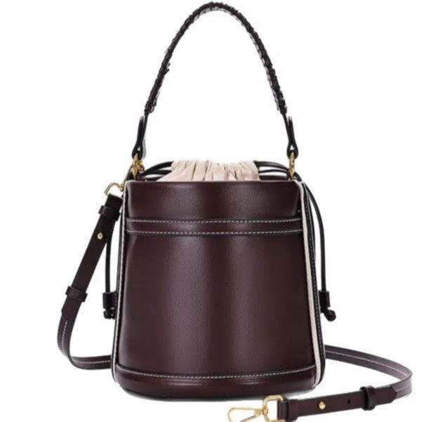 Brown PU cylindrical tote bag with dual handles, cross-body strap, and woven stitch detailing on a white background