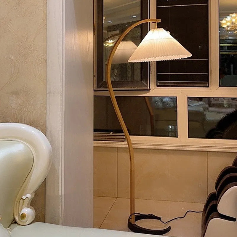 Retro vertical table lamp with a fabric shade in log white, placed on a bedside table.