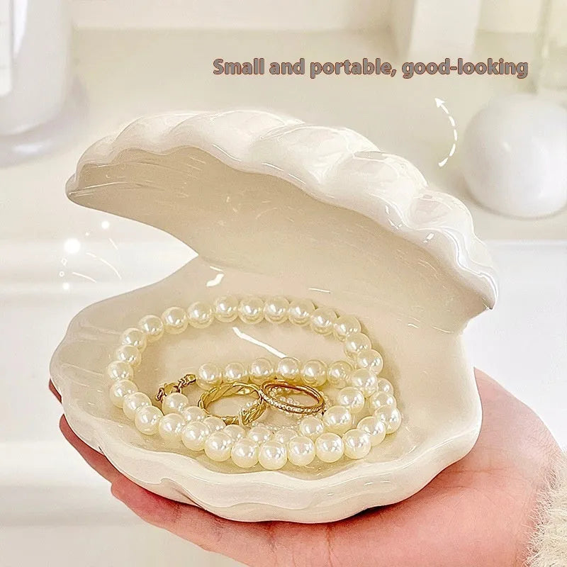 White porcelain decorative storage tray with a small built-in night light, holding jewellery on a bedside table