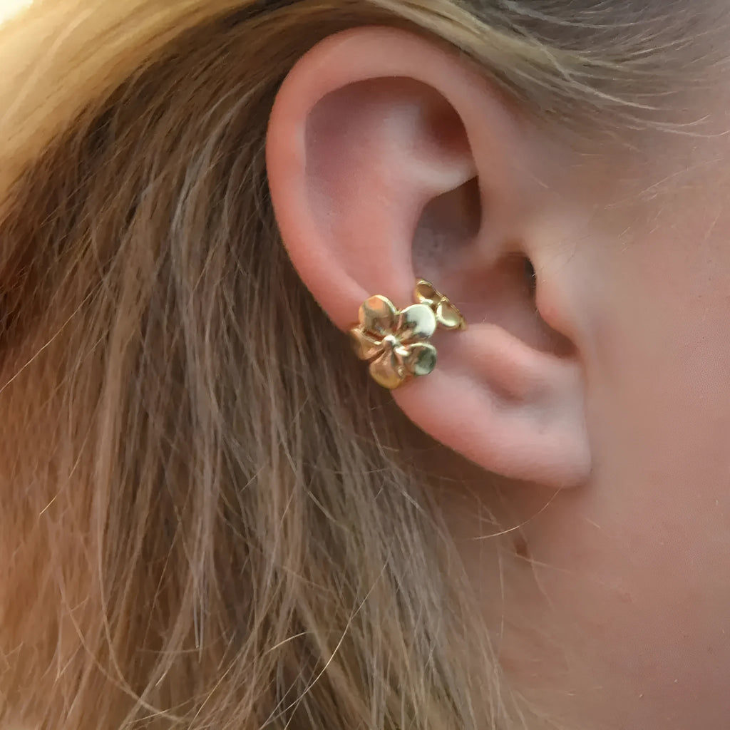 Gold-coloured drop earrings with a detailed starfish and conch shell design on a white background.