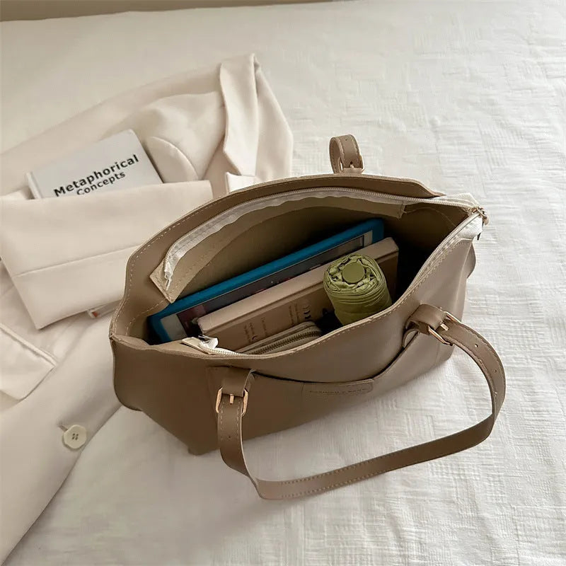 Women's square PU tote bag in black with double straps, showing external sandwich pocket and sewing line detail.