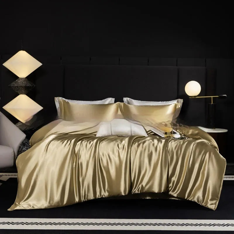Silk bed sheet four-piece set in a solid colour displayed on a bed, showing fitted sheet and pillowcases.