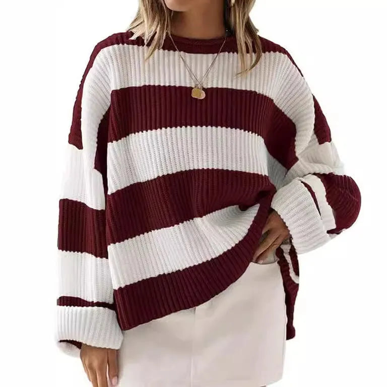 Woman wearing a loose striped sweater with long bell sleeves and white crocheted flower details on the front.