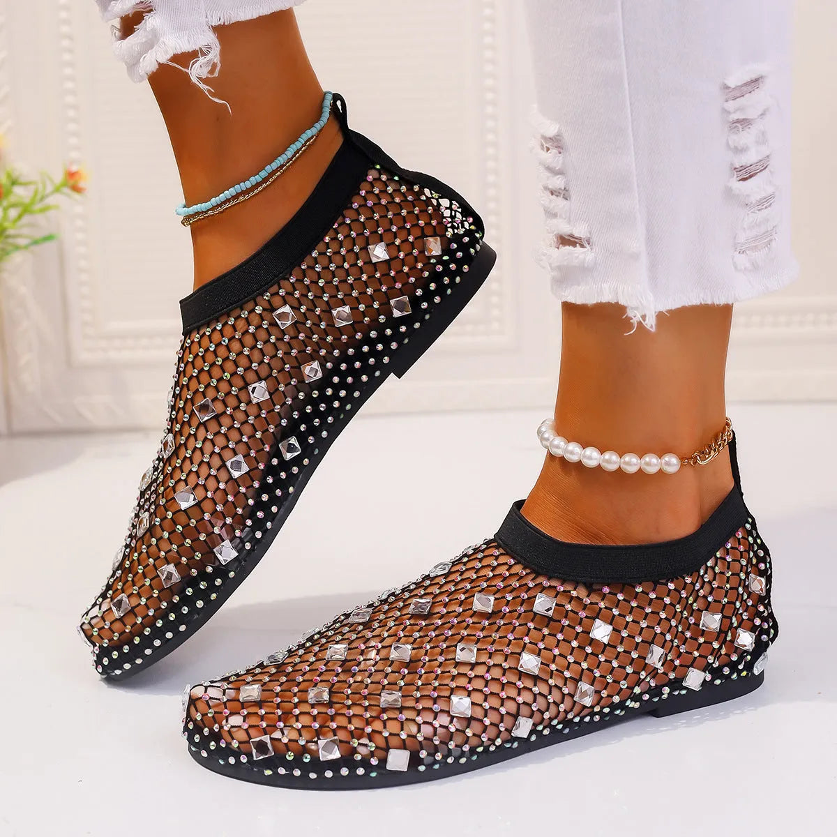 Colourful rhinestone detail on women's white mesh flat sandals with a rubber sole.