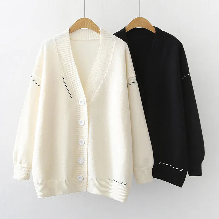 Women's loose black knitted cardigan coat with long sleeves on a hanger.