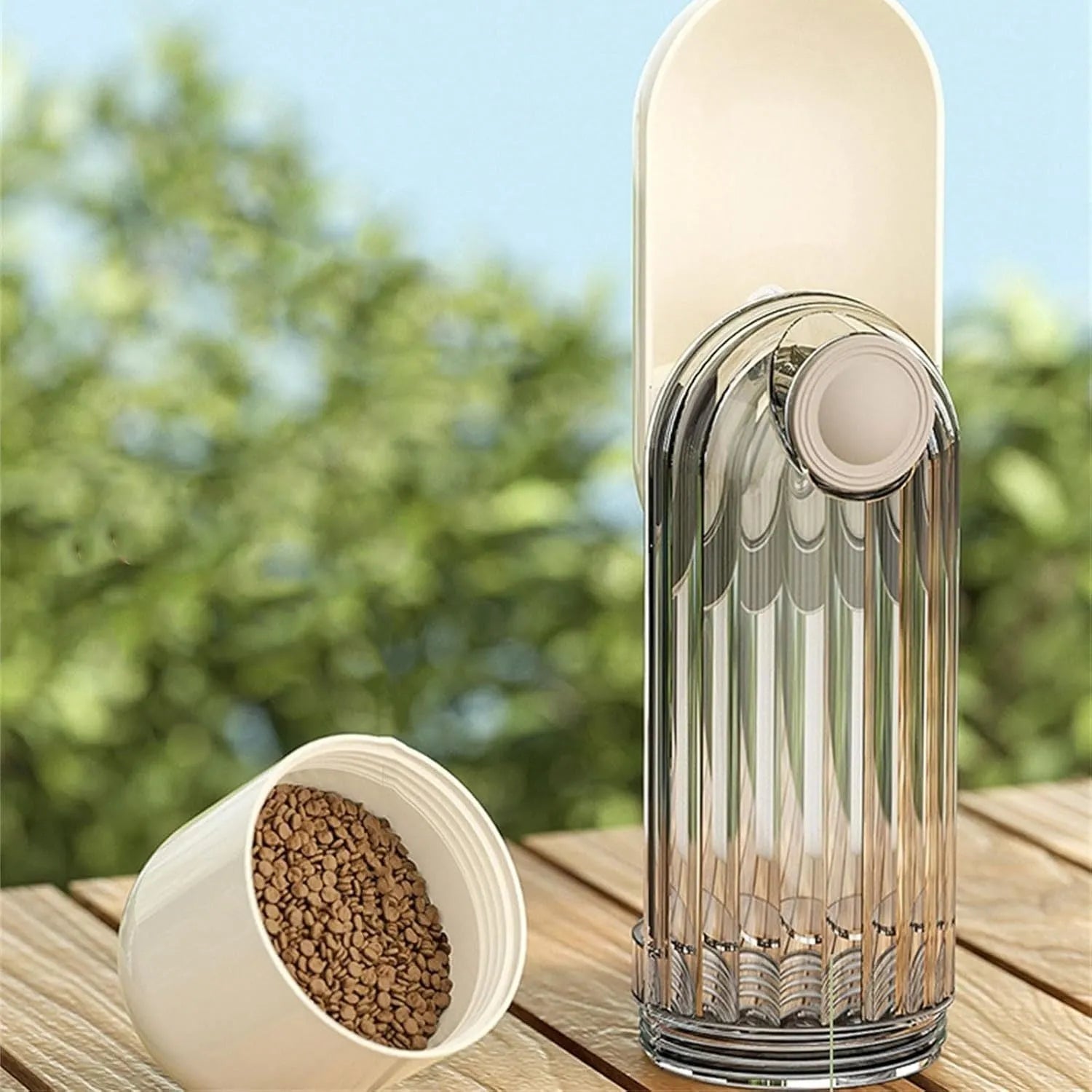 Beige foldable dog water bottle and food dispenser with large drinking opening, shown next to a leash.
