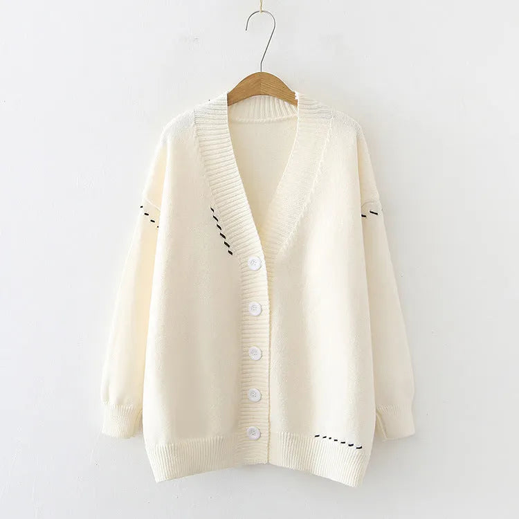 Women's loose black knitted cardigan coat with long sleeves on a hanger.