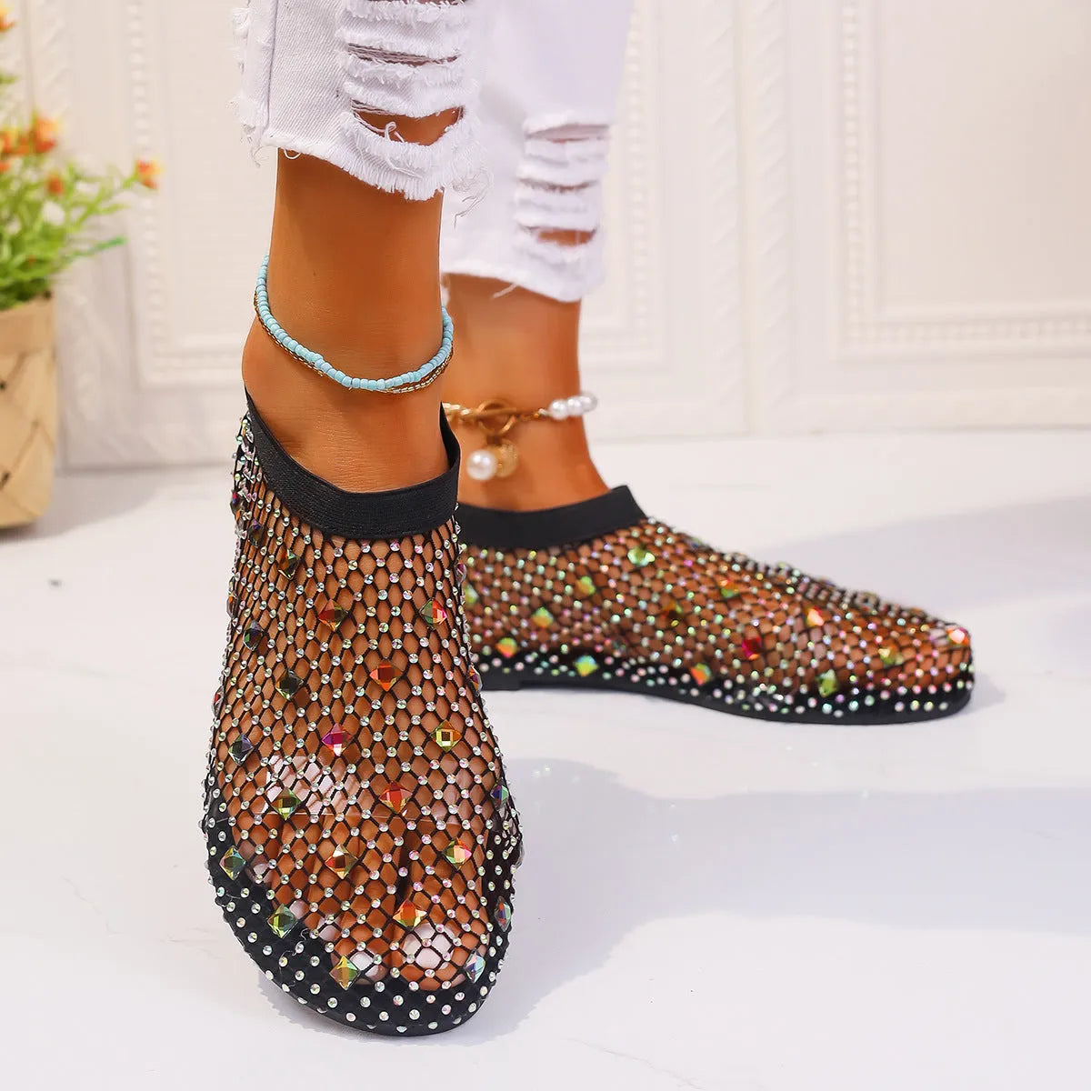 Colourful rhinestone detail on women's white mesh flat sandals with a rubber sole.