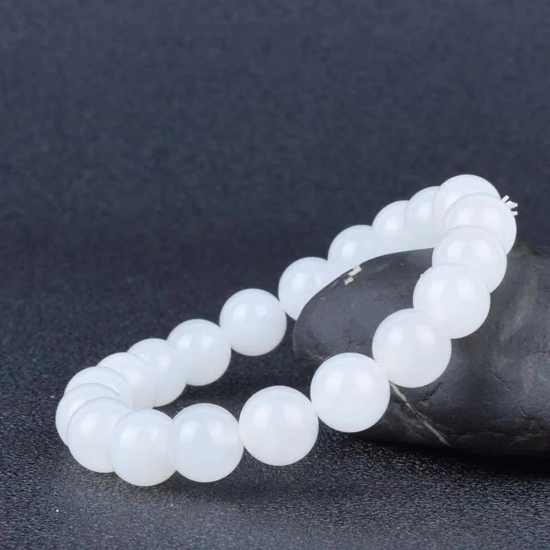 Hotan white jade goat fat round bead bracelet with 10mm Hetian jade beads on a neutral background
