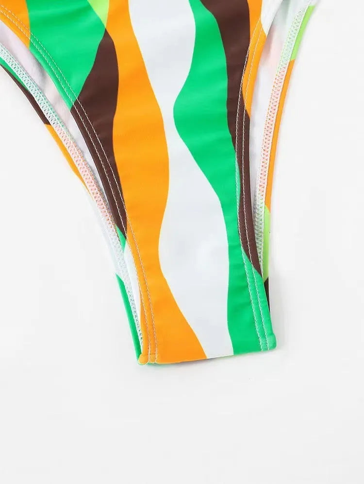 Women's yellow green printed bikini top and briefs with matching beach skirt laid flat.