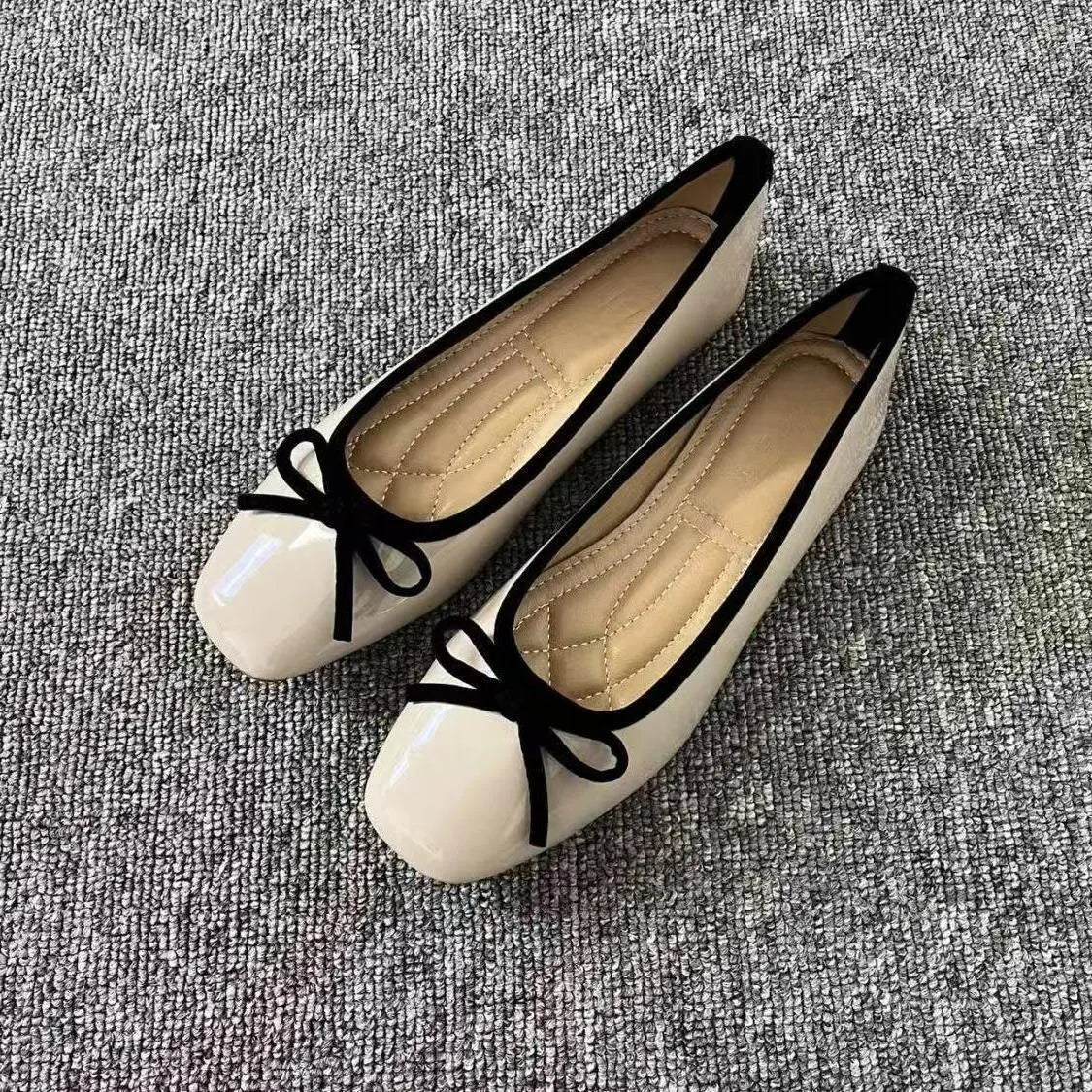 Pair of black patent leather Mary Jane flats with low heel and round toe