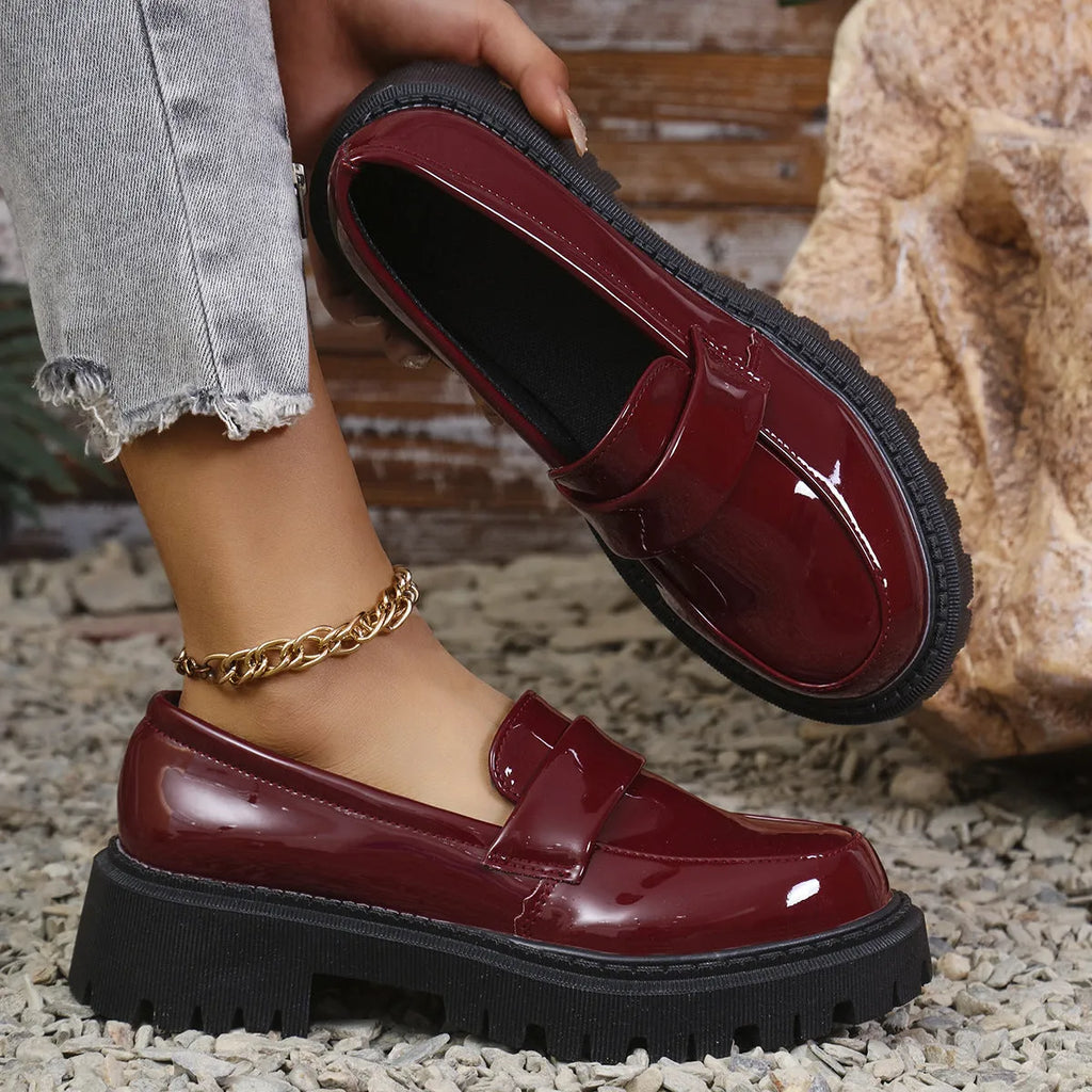Women's black slip-on loafers with a chunky platform heel and mid-top ankle cut.