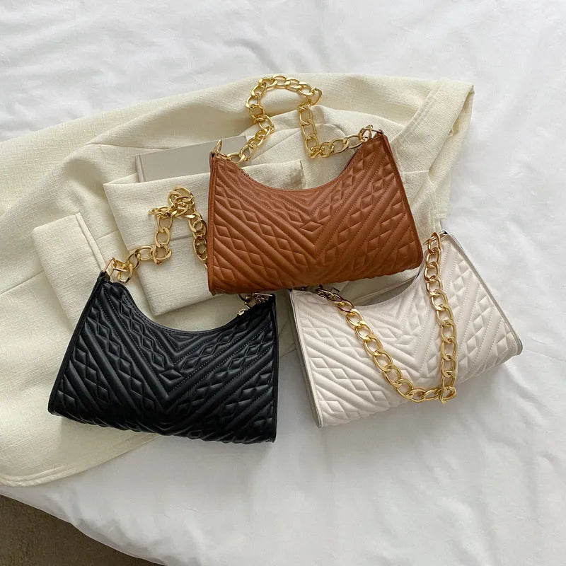 Brown pleated PU baguette shoulder bag with a top handle and long chain strap on a white background.