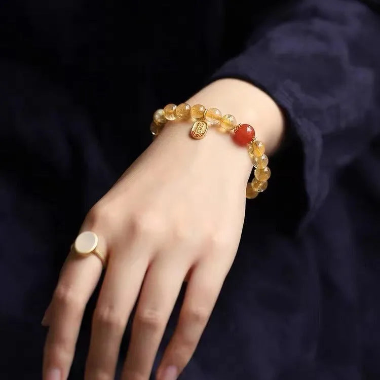 Natural red agate bead bracelet with gold ruby accents on a wrist, showing three bead size options.