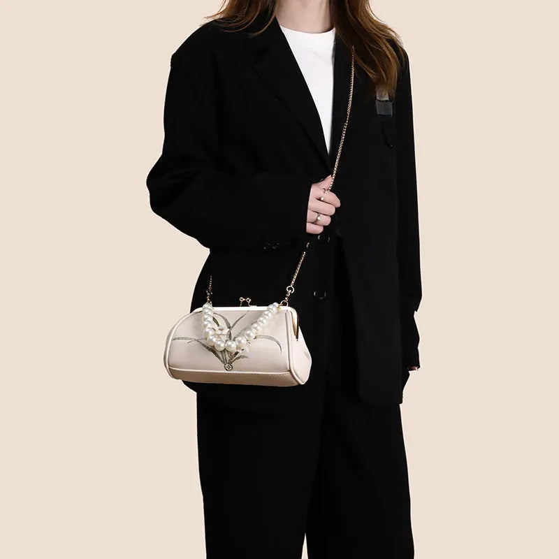 Beige women's shoulder bag with embroidery detail and shell-shaped design in soft PU leather