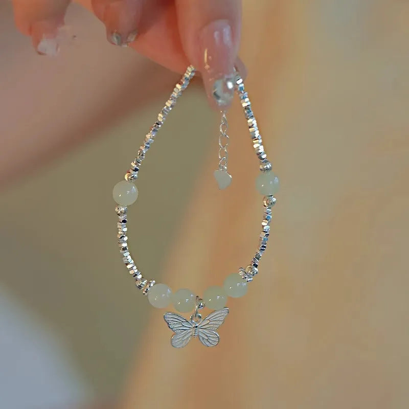 Women's copper butterfly jewellery set with electroplated silver finish, showing bracelet and necklace