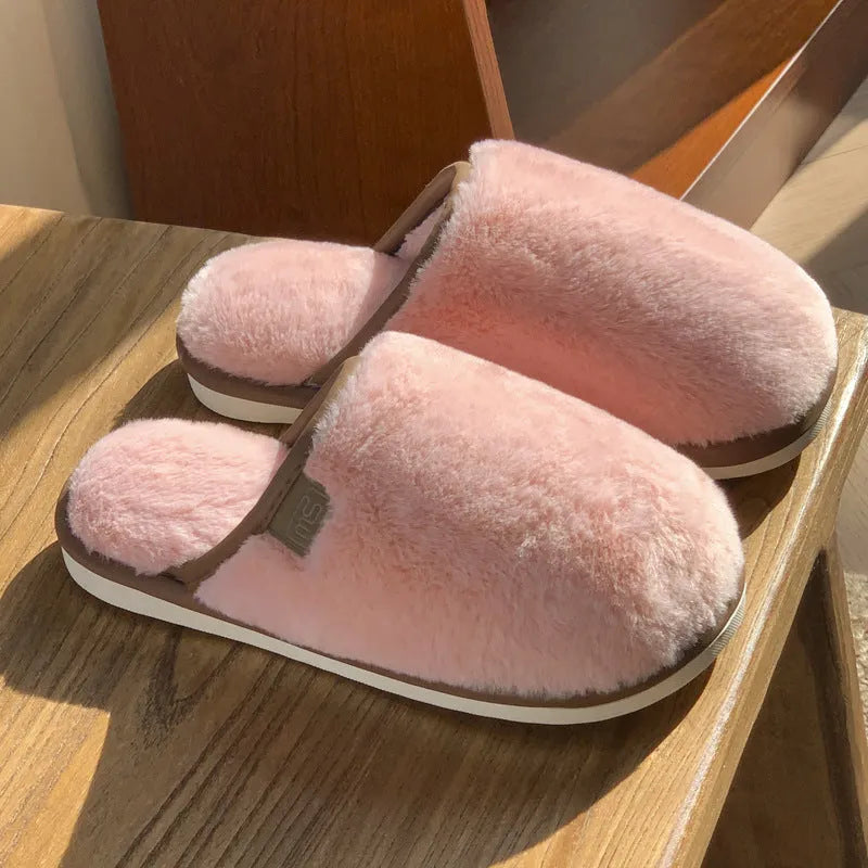Pair of solid-colour plush winter slippers with a PVC upper and textured non-slip sole.