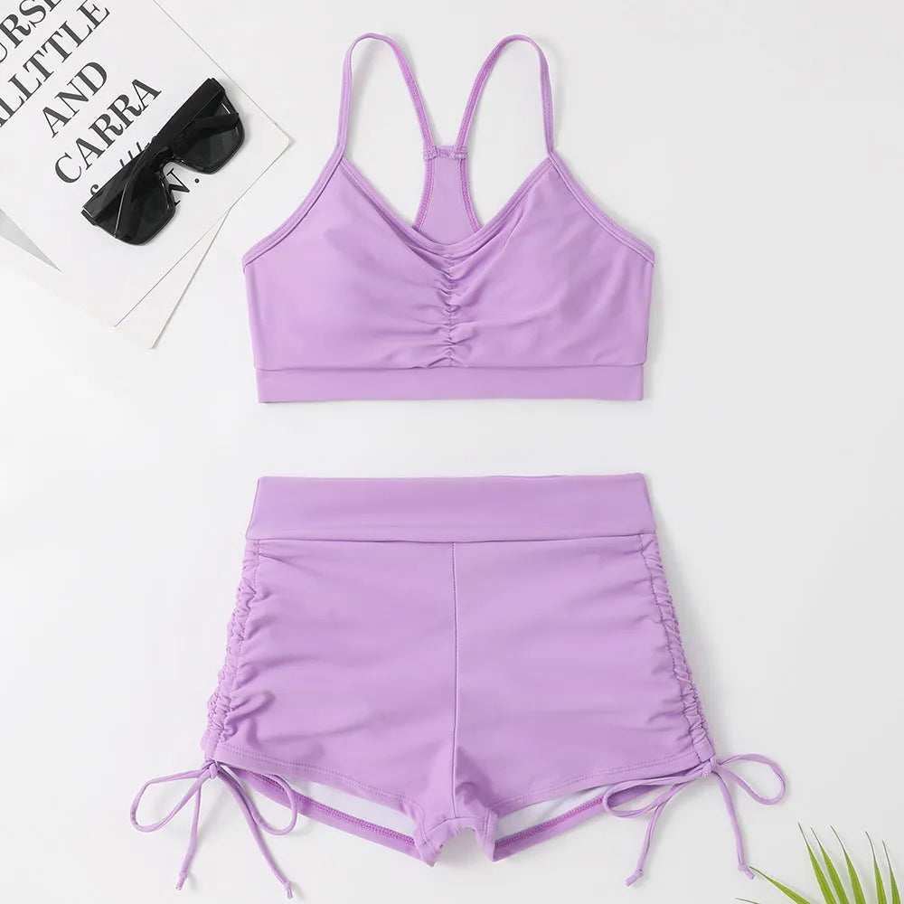 Purple and black women's high waisted bikini swimsuit with side splits.
