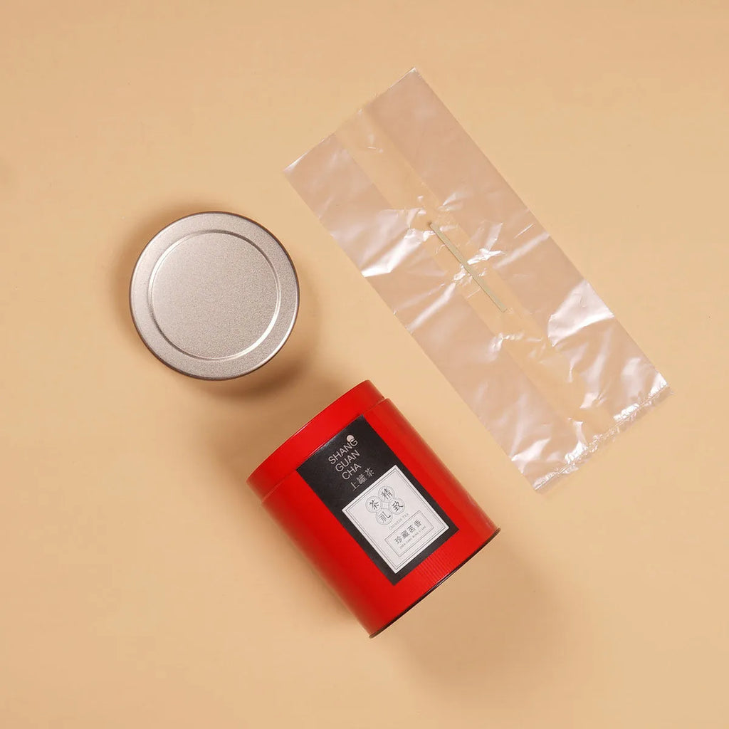 Green airtight tinplate tea storage can with sealed lid, 155mm tall.