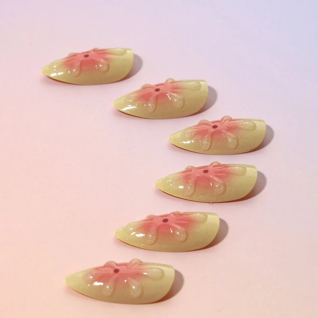 Plastic false nails with 3D cartoon flower design, jelly glue, and a nail file strip on a white background.
