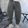 Man wearing loose grey cropped bamboo fibre sports pants in a casual setting.