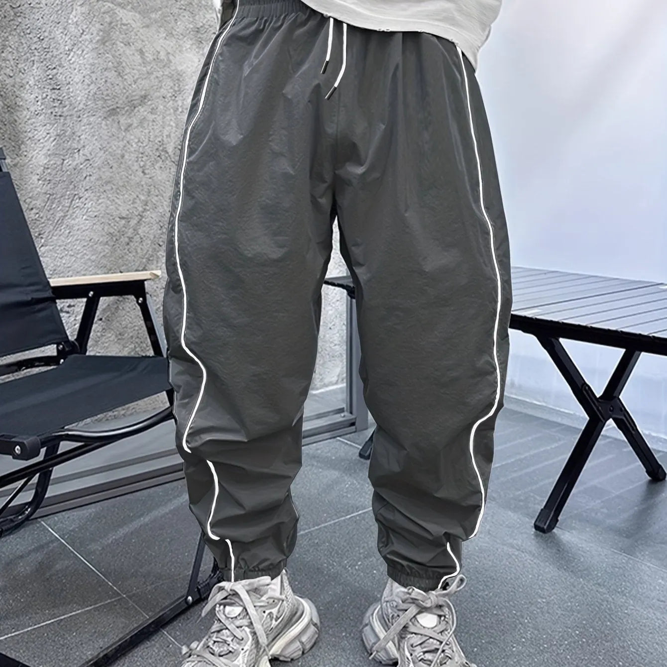 Man wearing loose grey cropped bamboo fibre sports pants in a casual setting.