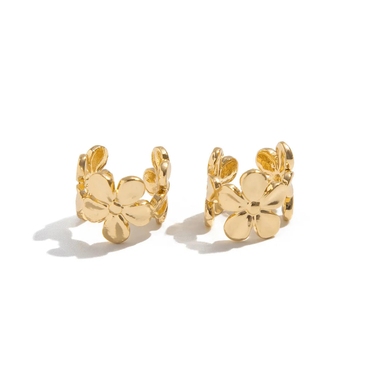 Gold-coloured drop earrings with a detailed starfish and conch shell design on a white background.
