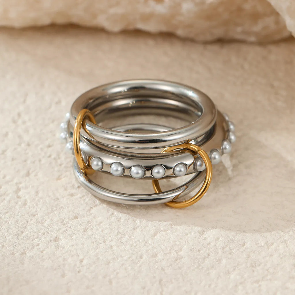 Stacked stainless steel rings with 18K gold plating in an exaggerated silhouette design.