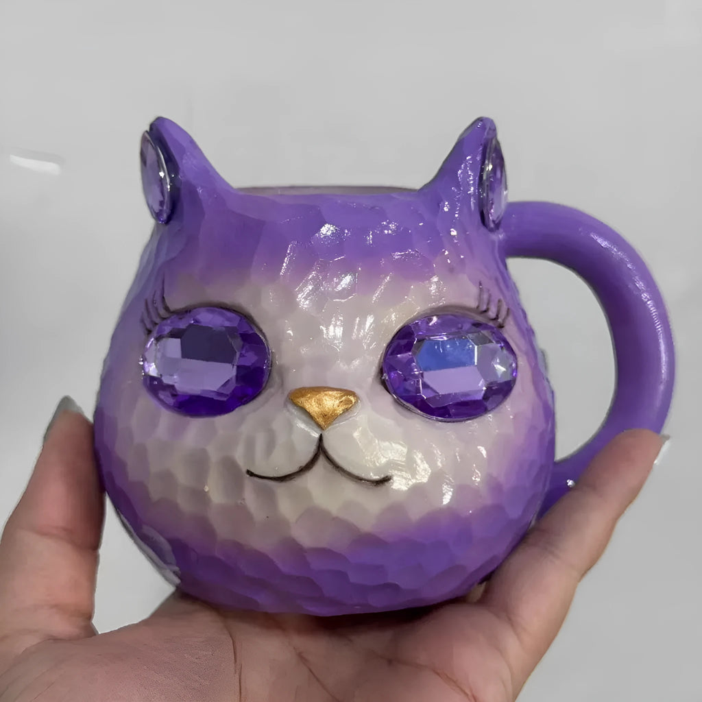 Small solid-colour resin cat cup craft figurine on a table, shown in purple, green, blue, and pink colour variants.