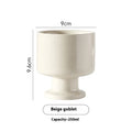 Hand-pinched irregular shaped solid colour ceramic mug on a table.