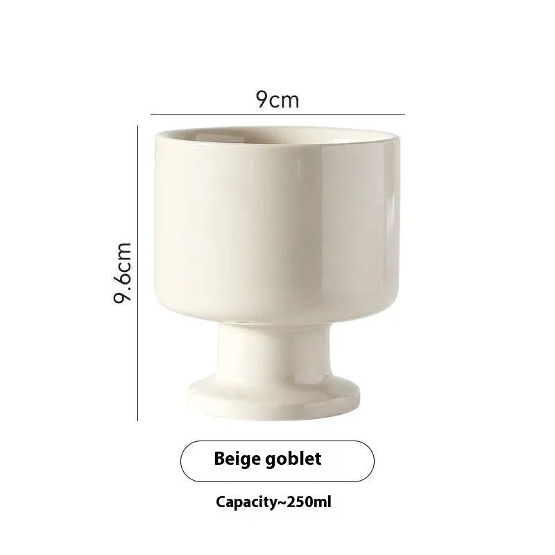 Hand-pinched irregular shaped solid colour ceramic mug on a table.