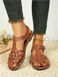 Dark brown women's Roman sandals with woven PU upper and buckle closure on a rubber sole.
